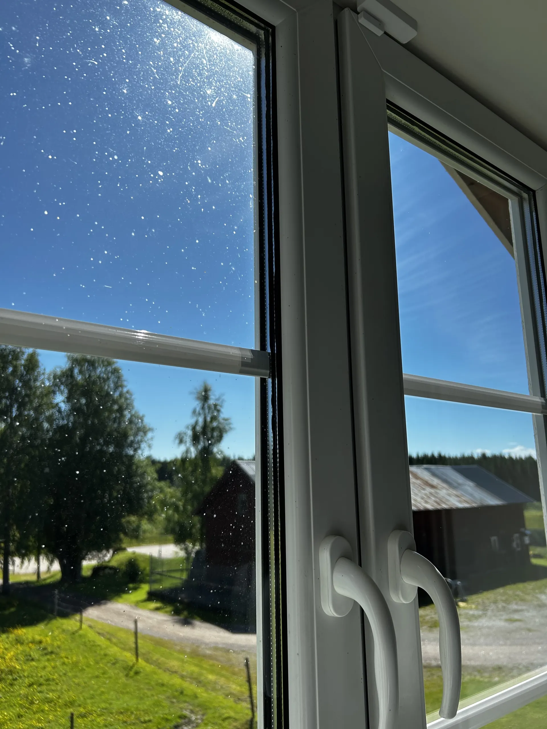 Utsikt genom ett fönster mot en lada